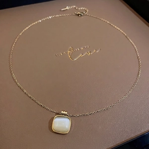 Collier en acier titane avec pierre œil de chat carrée sur présentoir en cuir brun