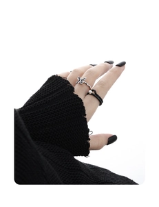 Detail view of S925 silver butterfly ring and black cord pearl ring on a hand