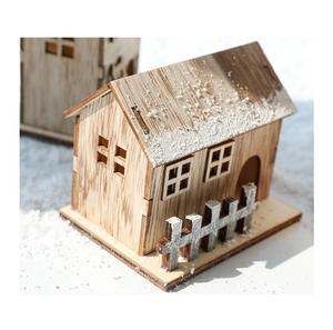 Detail of wooden Christmas house with faux snow and warm rustic finish