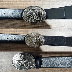 Detail of western cowboy belts with embossed scorpion, skull and star metal buckles