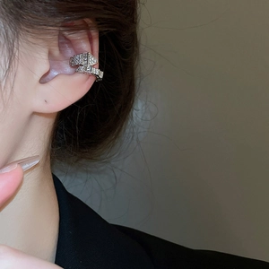 Macro shot of silver snake-shaped ear cuff with sparkling zircon inlay for non-pierced ears
