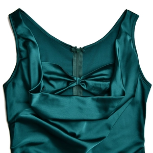 Détail d'une robe en satin vert foncé avec fermeture éclair invisible et nœud plissé