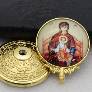 Macro shot of golden metal religious icon depicting the Virgin Mary with threaded base