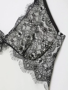Gros plan sur la dentelle noire en maille avec détails de cils délicats sur la robe