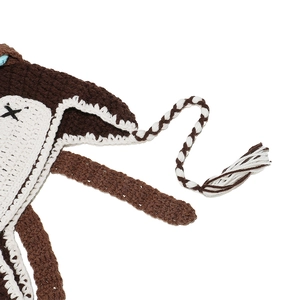 Macro shot of handmade crochet animal hat with long tassels and brown knit texture