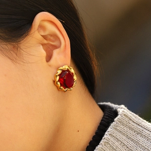 French vintage gold flower earrings with red gemstone shown on a model side view