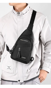 Detail of durable black cross-body chest bag featuring multiple zippers and fashion print