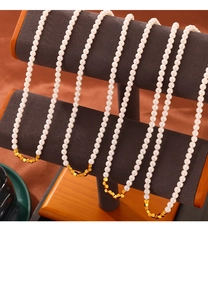 Detail showing elegant white pearls and golden cube metal beads on four snake chains