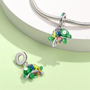 Macro detail of silver chameleon charm with colorful enamel and green crystals