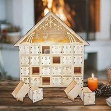 Detail of wooden 24-day advent calendar house with carved reindeer and LED lighting