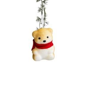 Cute foam Christmas bear ornament with red scarf hanging on festive pine branch