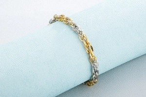 Detail of interlocking two-tone gold and silver titanium steel link bracelet