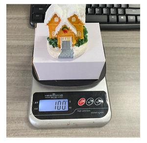 Detailed top view of a resin Christmas house decor being weighed on a digital scale