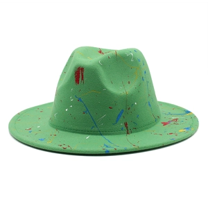 Detail of artistic paint splatter pattern on a green wool fedora hat for men and women
