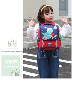 Outdoor shot of child wearing a red and blue dinosaur astronaut space backpack
