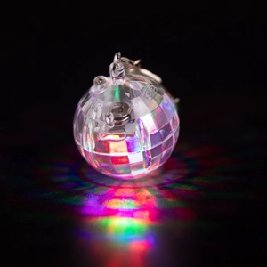 Close-up of a glowing LED disco ball keychain with vibrant colorful light reflections