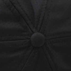 Close-up of black breathable honeycomb mesh fabric and top button on the sun hat