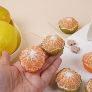 Realistic peeled orange candles with detailed white citrus pith texture in hand
