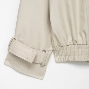 Close-up of beige waterproof short windbreaker showing cuff straps and elastic hem details