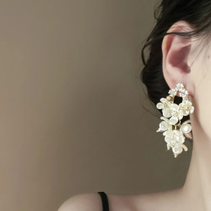 Close-up of pearl shell flower earrings with long tassel on a model side profile