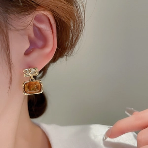 Close-up of vintage resin square stud earrings with textured gold plating for women