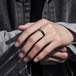 Detail view of matte black rotatable stress relief ring on finger for men