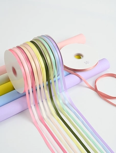 Macro shot of colorful 1cm solid ribbons in multiple rolls for floral DIY and gift wrapping