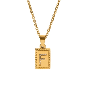 Macro detail of 18k gold plated rectangle pendant with crystal letter F and radial texture