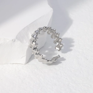 Close-up of adjustable silver geometric ring with punk thorn design on white stone