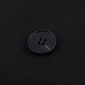 Detail of classic black four-hole matte buttons on an oversized double-breasted blazer