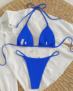 Detail of blue ribbed bikini showing high-cut bottom and halter top on beach mat