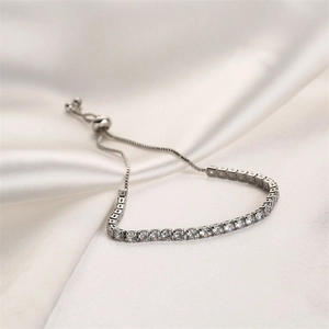 Detail of silver-tone tennis bracelet with zircon bar and adjustable bolo clasp closure
