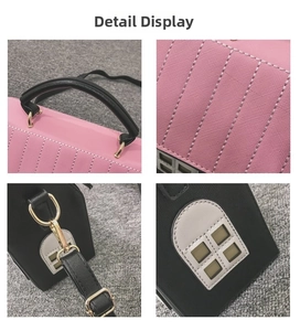 Vue détaillée du sac à main rose et noir avec coutures et quincaillerie dorée