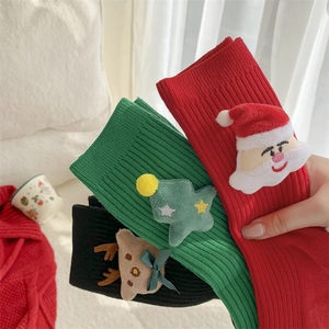 Three pairs of festive Christmas socks with 3D Santa, tree, and reindeer doll ornaments