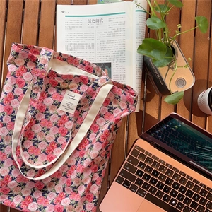Detailed macro of vintage rose floral cotton canvas tote bag with woven label detail