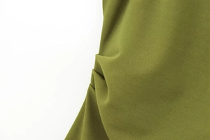 Detailed macro view of olive green crepe fabric featuring elegant pleated and ruched textures