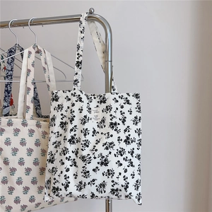 Detail view of cotton tote bags featuring vintage floral patterns and fabric patch labels