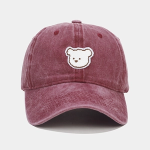 Close-up of cute cartoon bear embroidery on vintage washed red cotton baseball cap