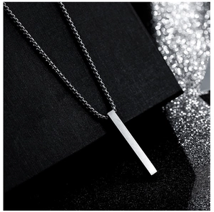 Macro shot of silver bar pendant necklace with box chain on a textured black surface