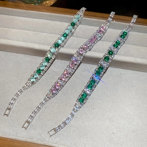 Detailed view of silver bracelets with colorful square zircons in a jewelry tray