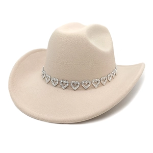 Détail du chapeau de cowboy beige avec ruban décoratif à cœurs métalliques argentés