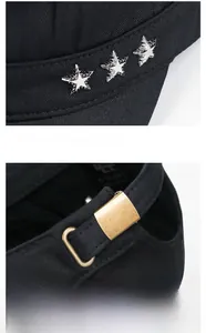 Detail of silver metal stars and adjustable brass buckle on a black cotton flat top cap