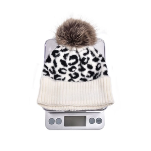 Detailed view of leopard knit beanie weighing approximately 127g on digital scale
