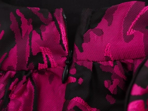Close-up of pink jacquard flower pattern and invisible zipper on black short dress