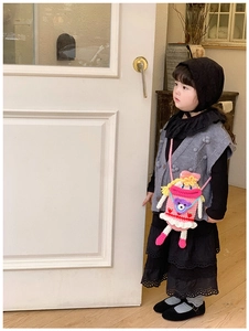 Borsa a tracolla per bambini all'uncinetto rosa fatta a mano indossata da una piccola modella