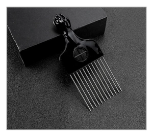 Close-up of stainless steel afro hair pick with classic black fist shaped handle