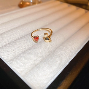 Close-up of gold dragon ring featuring a red heart stone and a small 3D cat sculpture