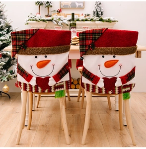 Detailed view of two Christmas snowman chair covers in festive red and white plush fabric