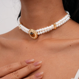 Close-up of double-layer pearl necklace featuring a tiger eye stone and crystal inlay