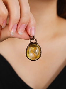 Vintage bronze necklace pendant featuring a raw yellow crystal with natural inclusions